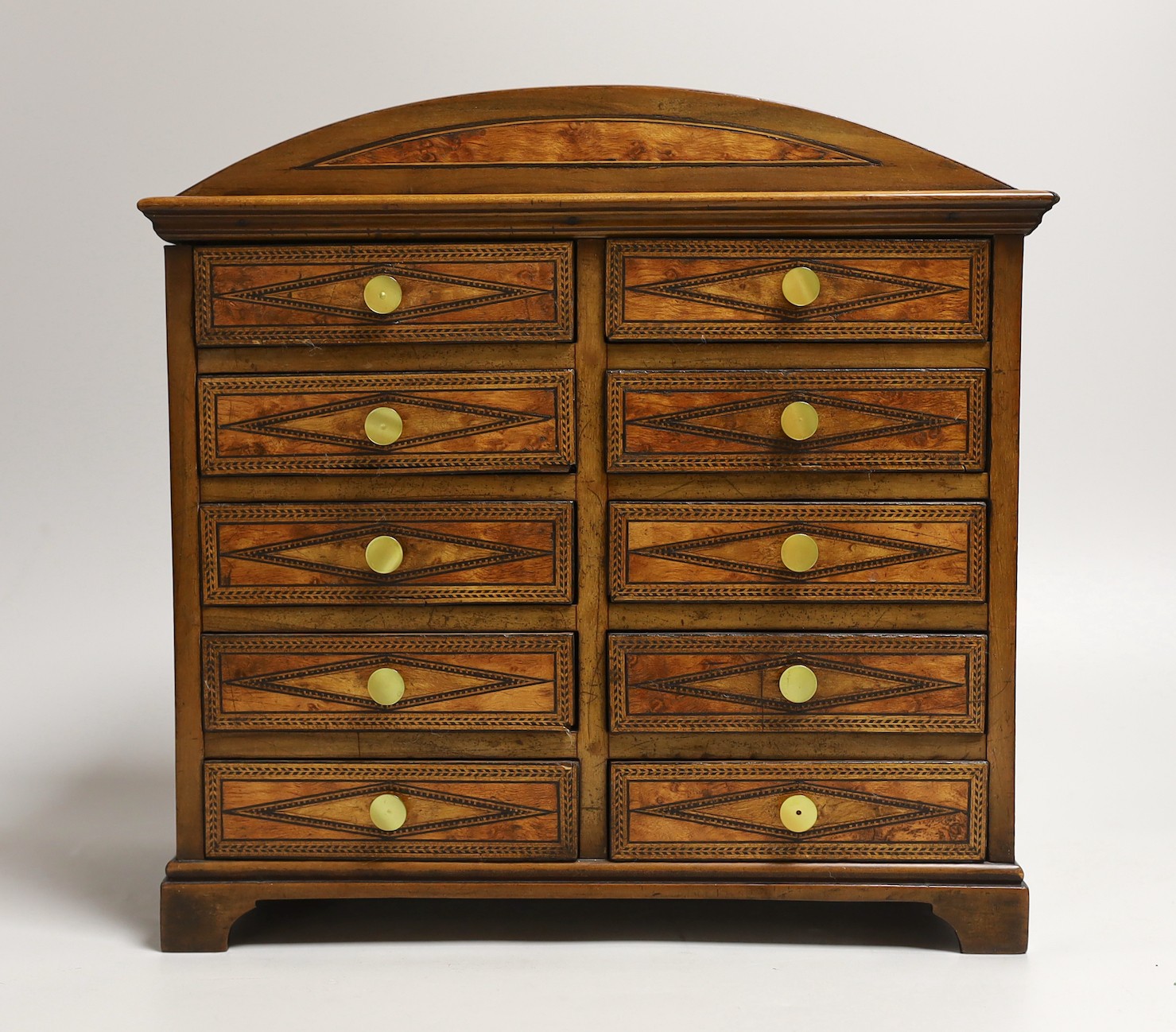 A Sorrento inlaid bird’s eye maple ten drawer miniature chest, 27cms x wide 26.5 cms high